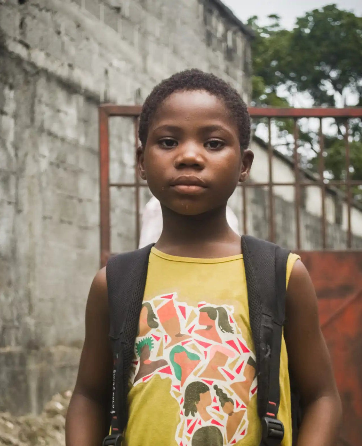 A student wearing a yellow tank top and black backpack.